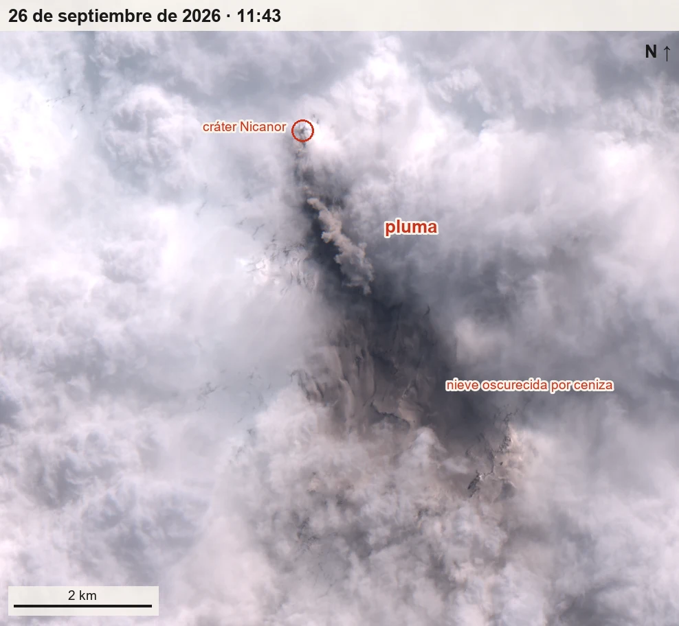 Imagen satelital en color natural: un manto de nubes blancas cubre casi todo; desde el cráter, marcado con un
       círculo rojo, sube una pluma gris parda que se inclina hacia el sureste por encima de las nubes, y bajo ella, en un
       claro, se ve nieve de color pardo oscuro con el relieve de las laderas.